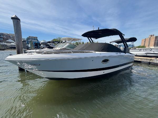 Chaparral 250 OSX 2025 Chaparral 250 OSX boat docked in marina, featuring sleek design and black canopy.
