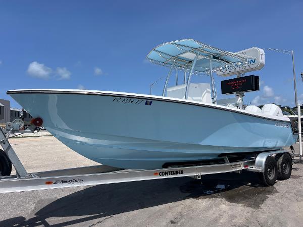 Contender 25 Tournament 2023 Contender 25 Tournament boat on trailer, light blue hull, sunny day.