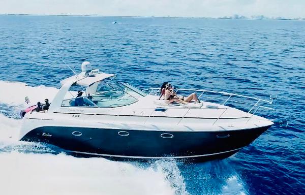 Rinker Fiesta Vee 410 2005 Rinker Fiesta Vee 410 cruising on open water with passengers relaxing on deck.