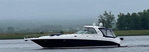 Sea Ray Sundancer 460 2004 Sea Ray Sundancer 460 yacht cruising on a misty lake with lush green shoreline.