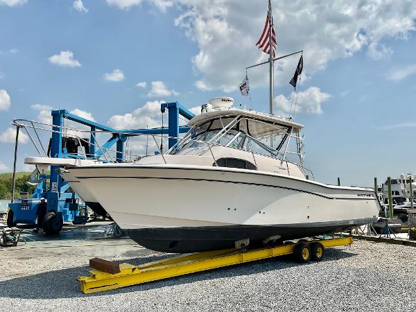 Grady-White Marlin 300 2005 Grady-White Marlin 300 boat on trailer, flags flying, under a partly cloudy sky.