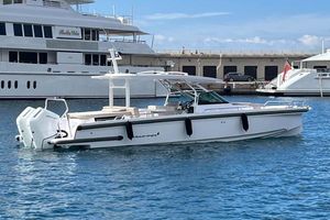 Axopar 37 Sun-Top 2024 Axopar 37 Sun-Top boat docked in marina, sleek design, clear blue water.