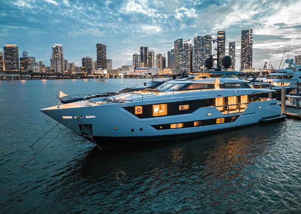 Custom Line 106 Luxurious 2023 Custom Line 106 yacht docked at city waterfront during twilight.