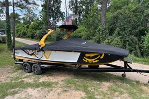 Tigé RZ4 2013 Tigé RZ4 boat on trailer, covered, parked outdoors near trees.