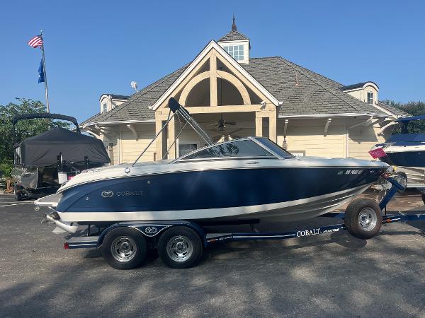 Cobalt 200 2012 Cobalt 200 boat on trailer, parked in front of a building with a gabled roof.