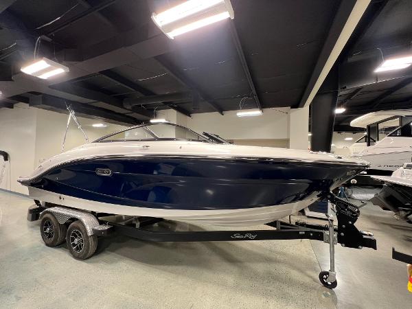 Sea Ray SPX 210 2025 Sea Ray SPX 210 boat on trailer in showroom.