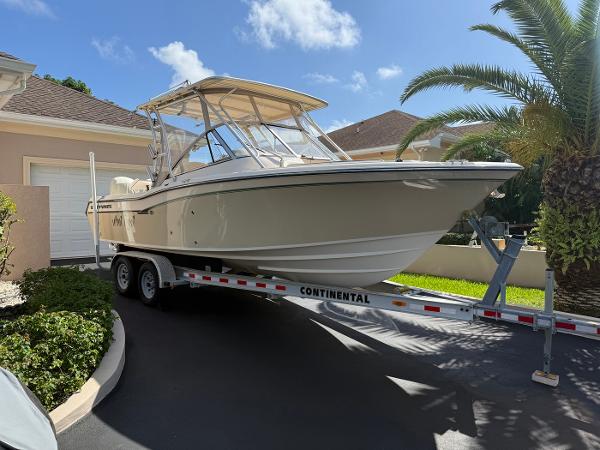 Grady-White Freedom 255 2012 Grady-White Freedom 255 boat on trailer, parked in driveway under clear sky.