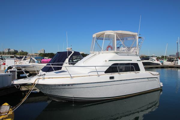 Mainship 31 Sedan Bridge 1995 Mainship 31 Sedan Bridge boat docked in marina under clear blue sky.