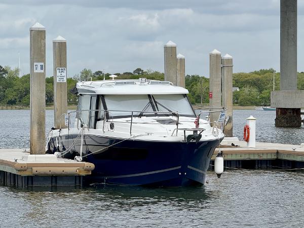 Jeanneau NC 1095 Coupe 2022 Jeanneau NC 1095 Coupe docked at a marina under cloudy skies.