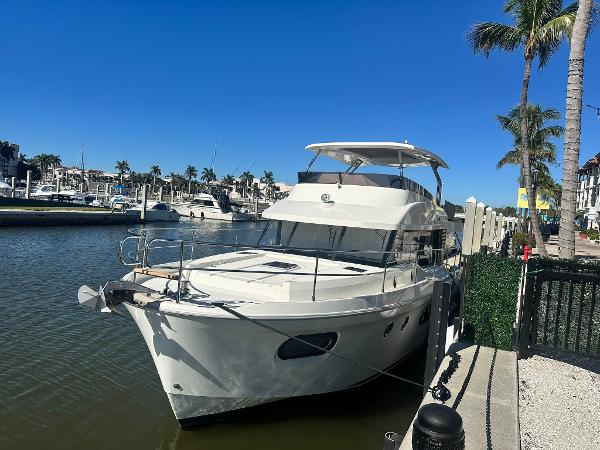 Beneteau Swift Trawler 48 2023 Beneteau Swift Trawler 48 docked by palm trees in a sunny marina.