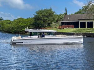 Axopar 37XC CROSS CABIN BRABUS Trim 2024 Axopar 37XC CROSS CABIN BRABUS Trim boat cruising on a serene river.