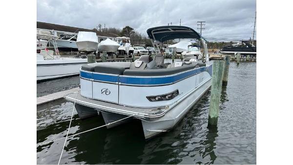 Avalon 2585 VRB 2023 Avalon 2585 VRB pontoon boat docked in a marina, featuring sleek design and blue accents.