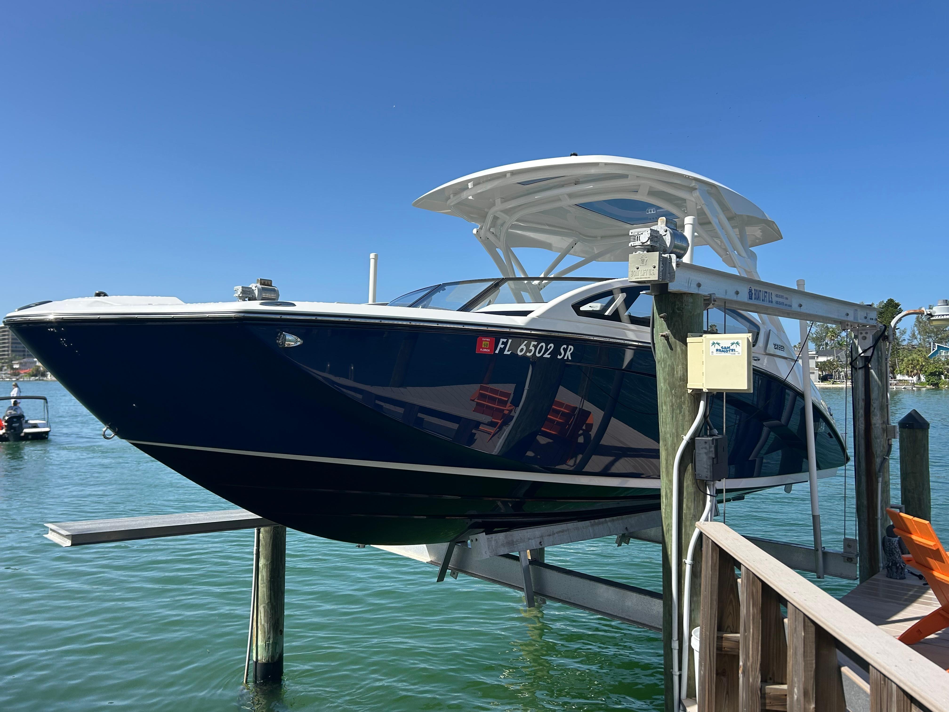 Yamaha Boats 275 SD 2020 Yamaha Boats 275 SD on lift, docked by clear blue water.