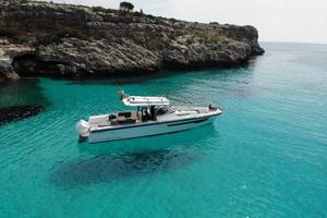 Nimbus T11 T Top 2021 Nimbus T11 T Top boat in clear turquoise water near rocky cliffs.