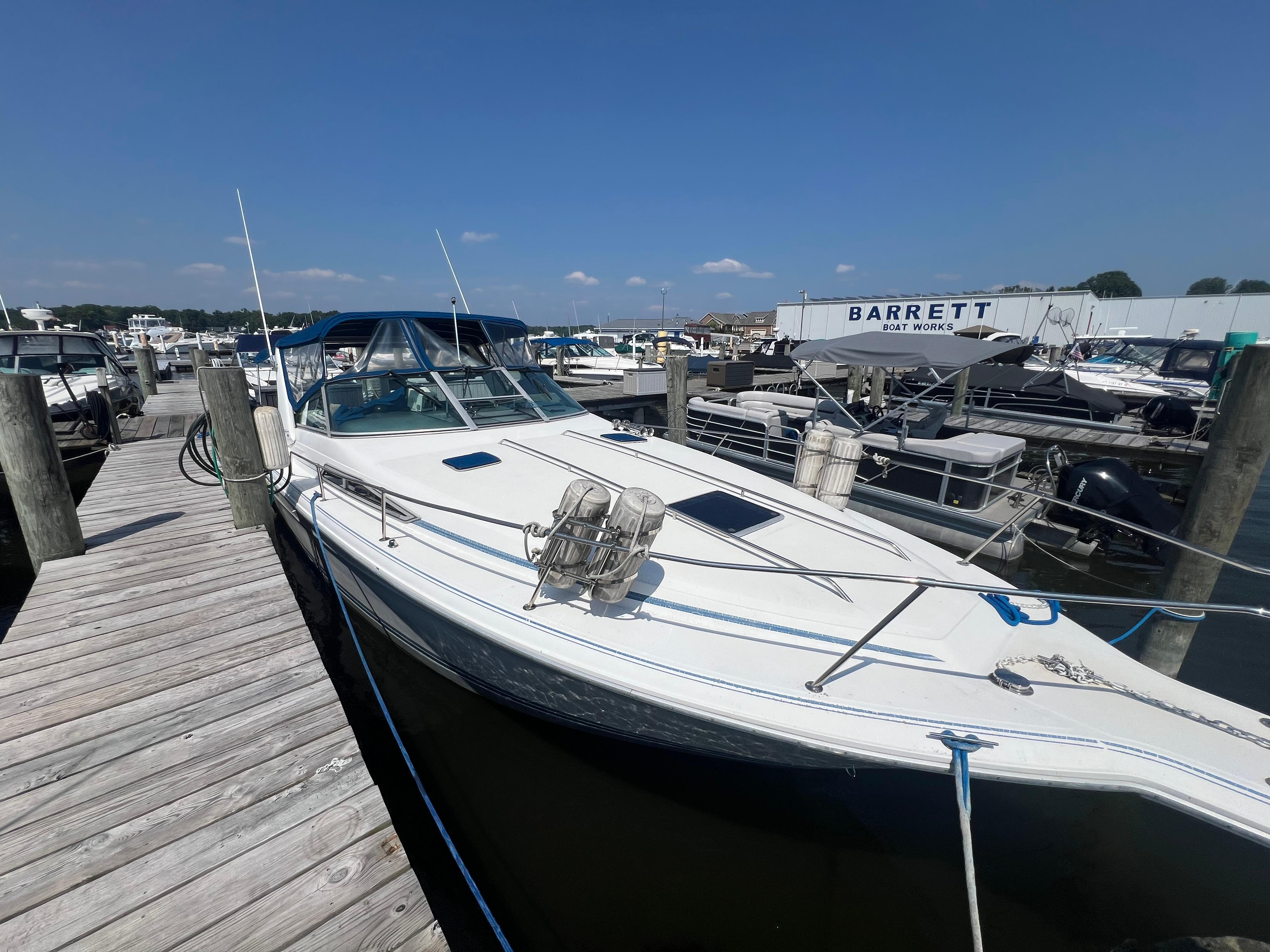 Sea Ray 310 Sundancer 1991 Sea Ray 310 Sundancer docked at marina under clear blue sky.