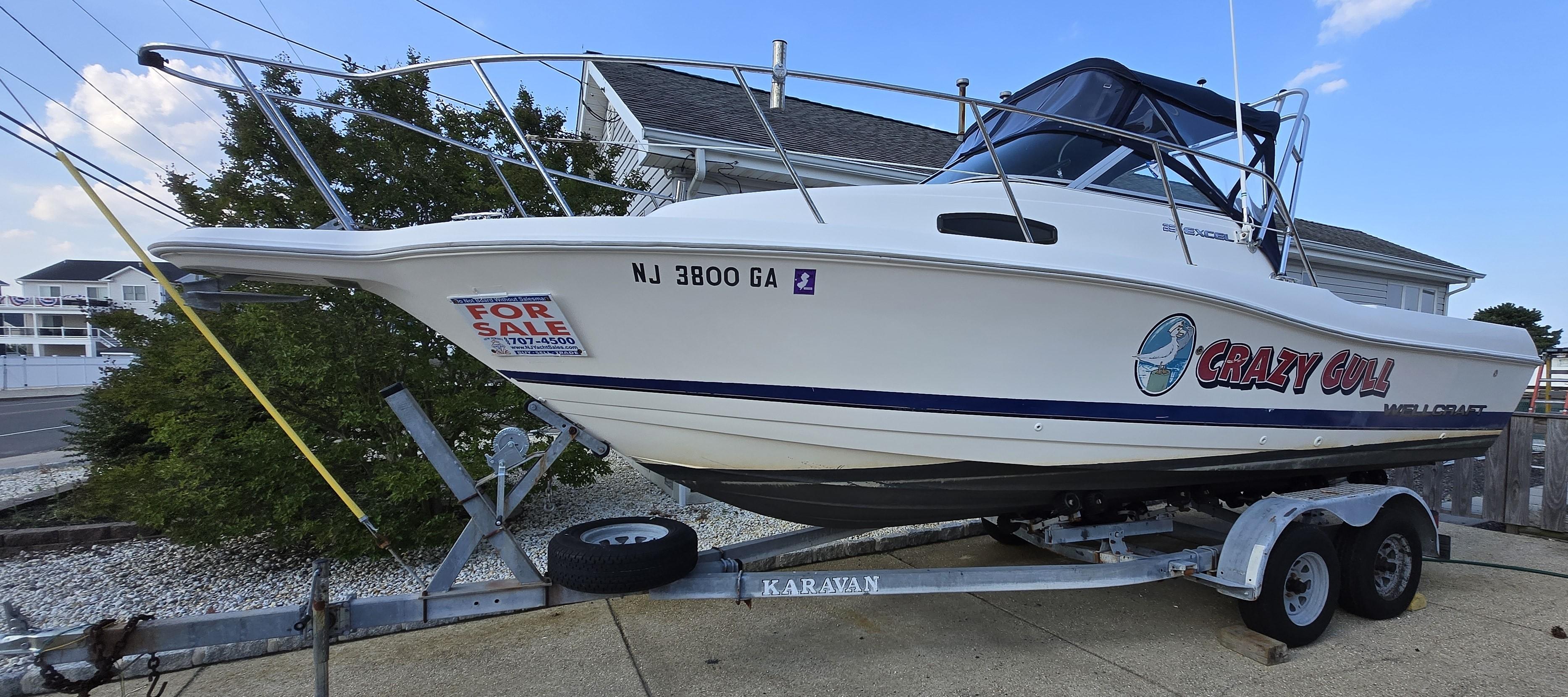 Wellcraft Excel 23 Walk Around 1996 Wellcraft Excel 23 Walk Around boat on trailer, for sale, with "Crazy Gull" decal.