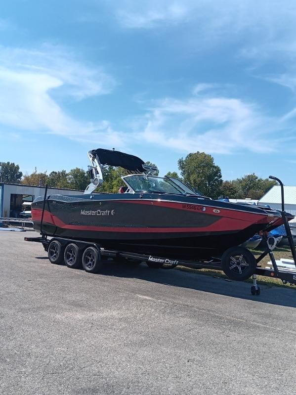 MasterCraft X26 2021 MasterCraft X26 boat on trailer under clear sky.
