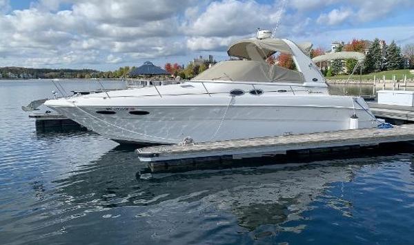 Sea Ray 310 Sundancer 2001 Sea Ray 310 Sundancer docked on a calm lake under a cloudy sky.