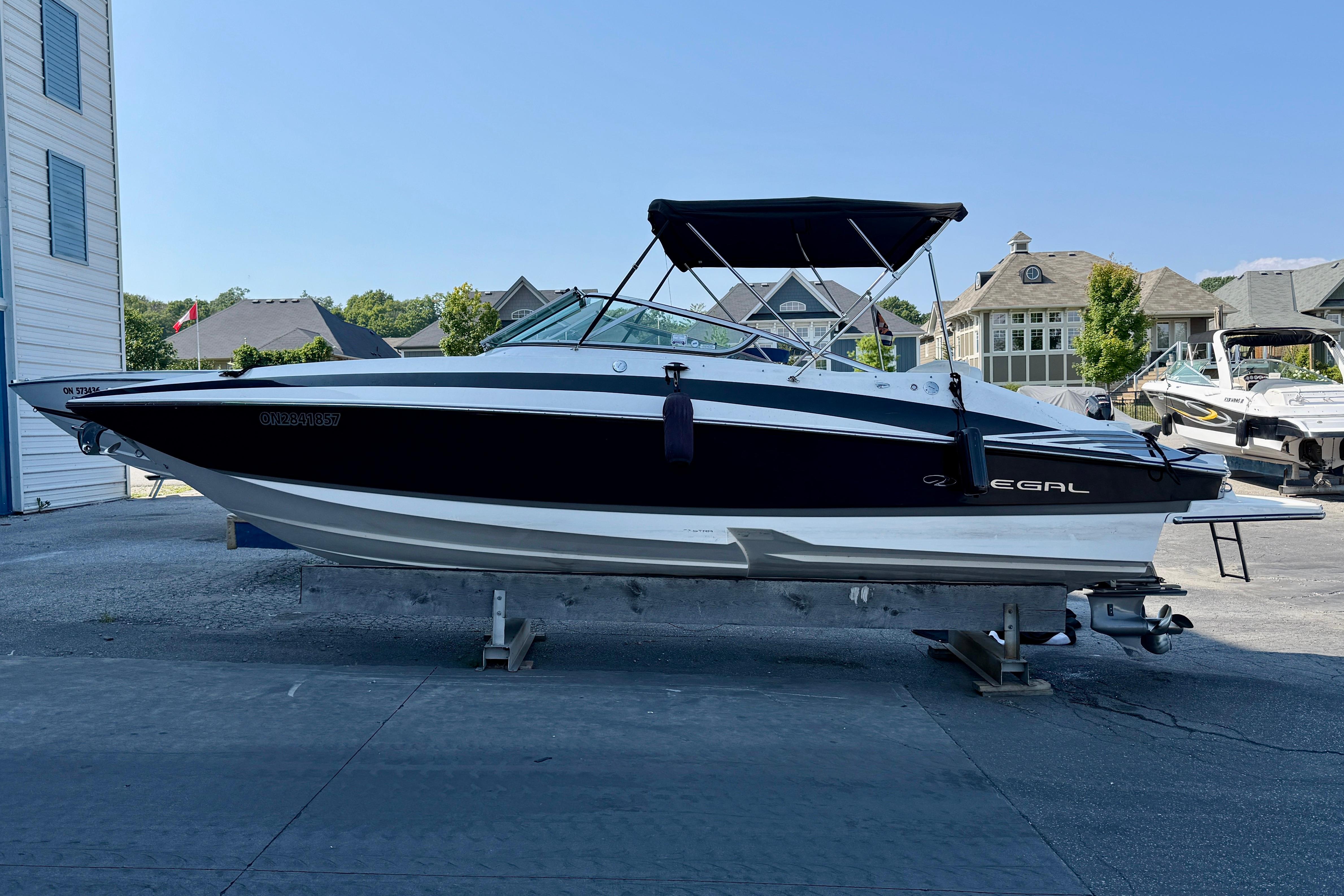 Regal 2520 FasDeck 2011 Regal 2520 FasDeck boat on trailer, black and white design, parked outdoors.