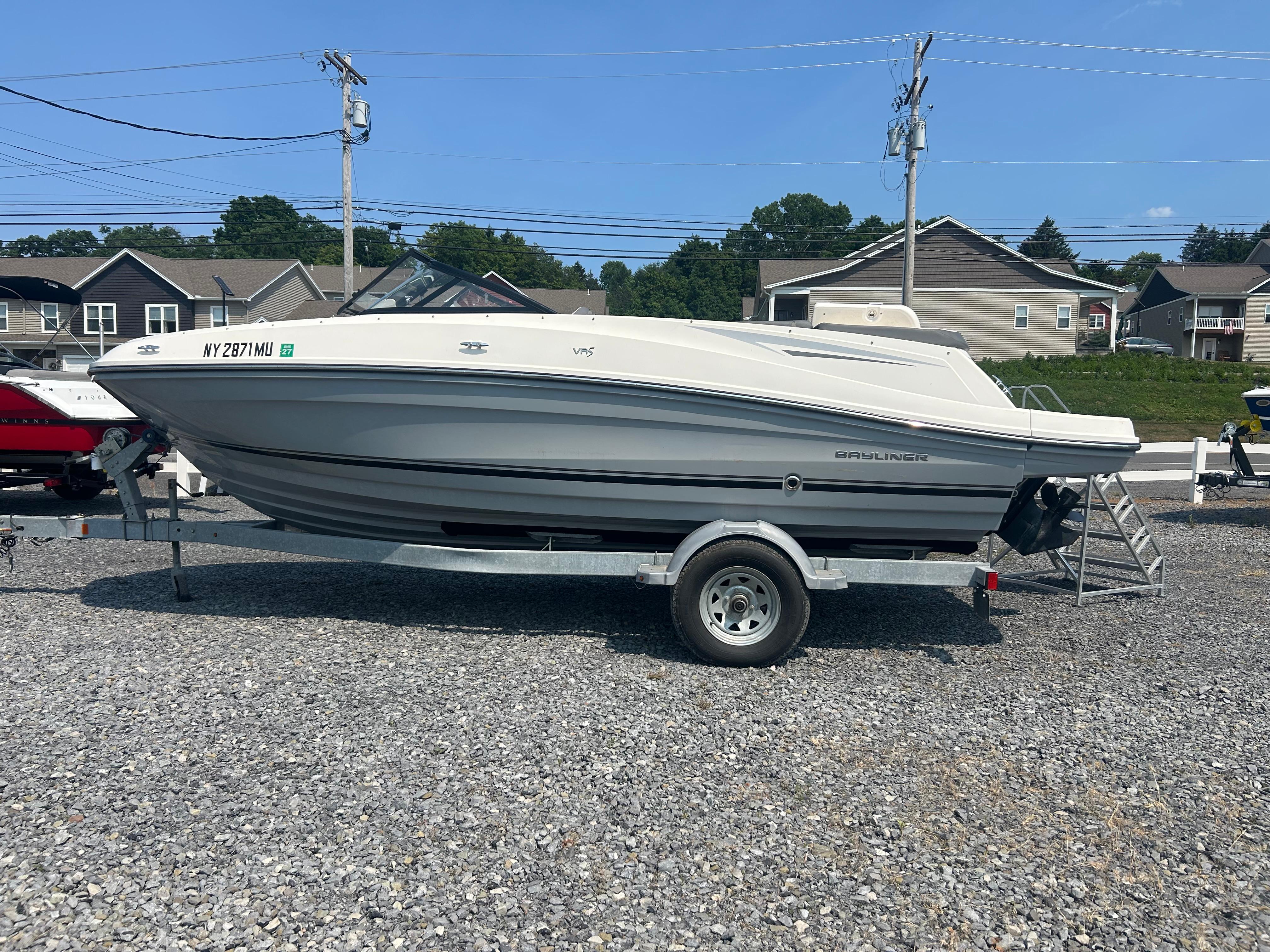 Bayliner VR5 Bowrider I/O 2017 Bayliner VR5 Bowrider I/O on trailer, parked on gravel lot under clear sky.