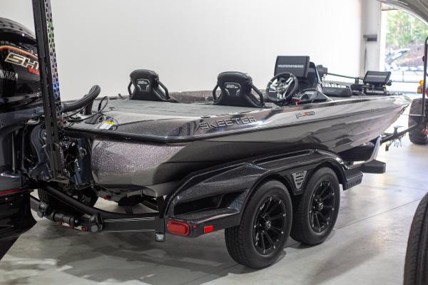 Skeeter FXR 20 LE 2025 Skeeter FXR 20 LE fishing boat in showroom, featuring sleek design and dual axle trailer.