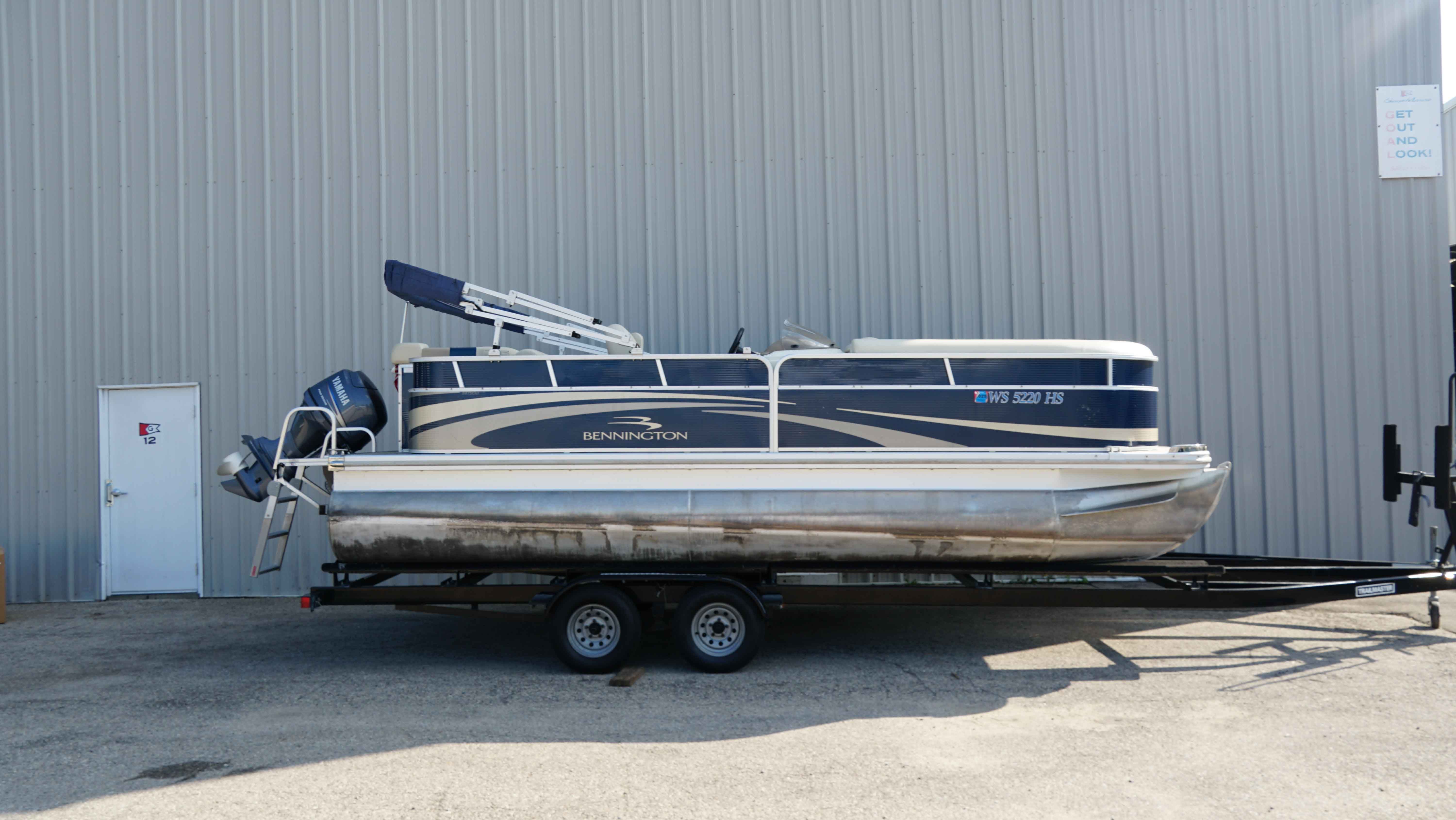 Bennington 2075 GLI 2010 Bennington 2075 GLI pontoon boat on trailer, parked by a metal building.