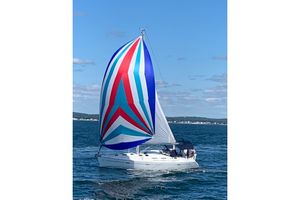 Beneteau 393 Sailing yacht Beneteau 393 (2003) with colorful spinnaker on open water.