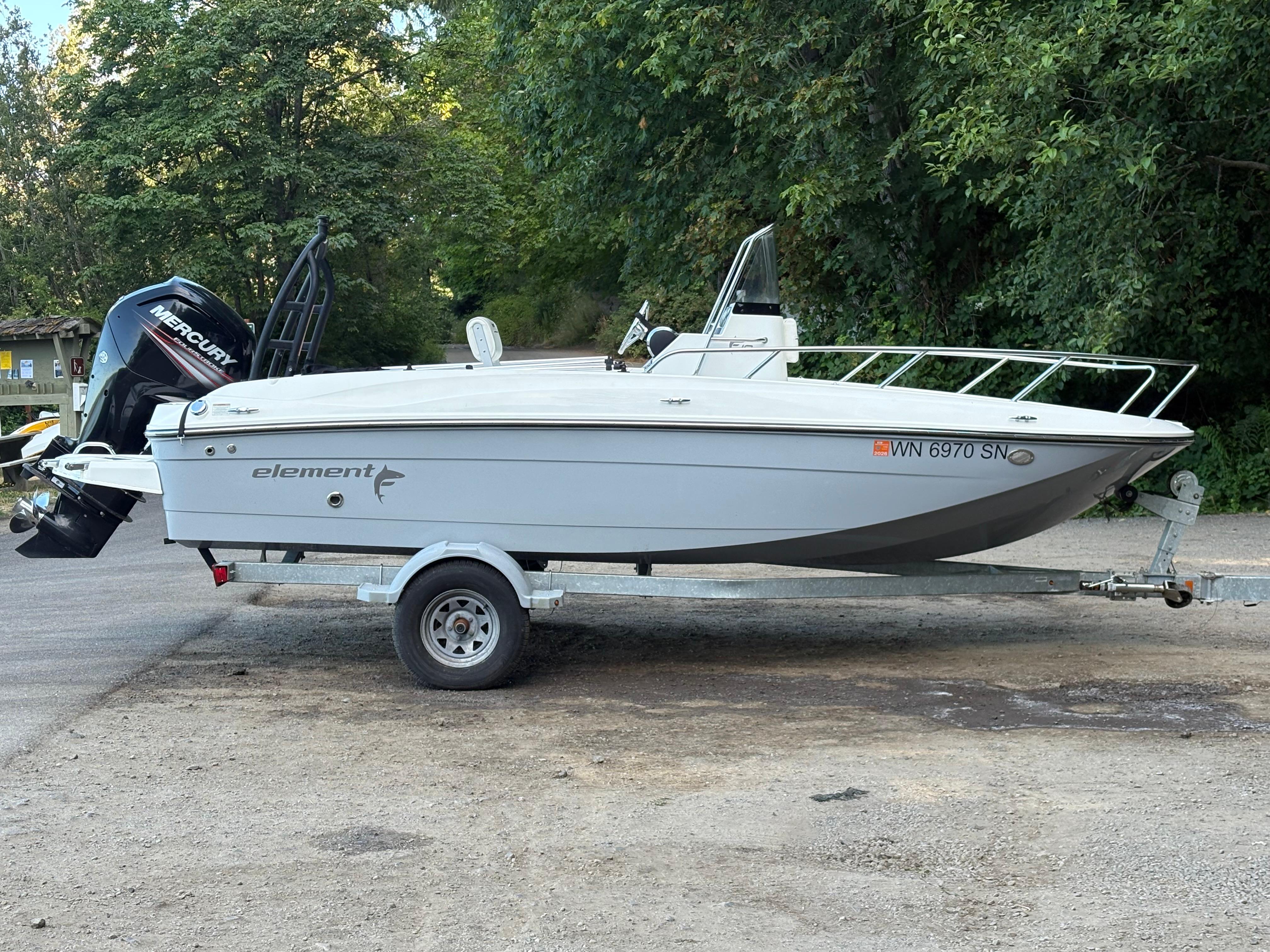 Bayliner Element F18 2018 Bayliner Element F18 boat on trailer, parked outdoors with trees in background.