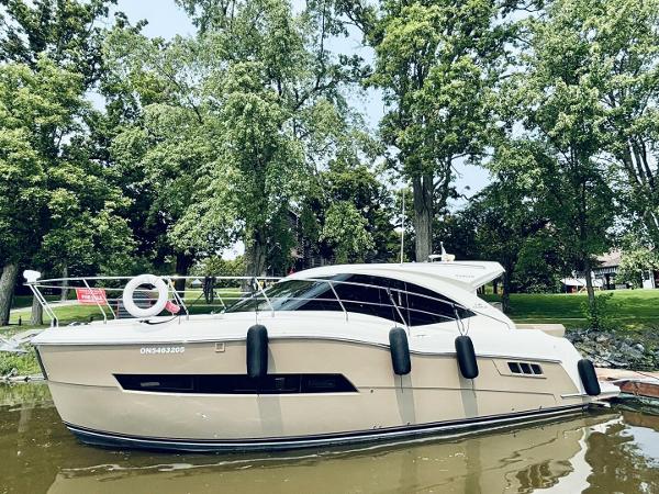 Carver C37 Coupe 2017 Carver C37 Coupe yacht docked by lush green trees.