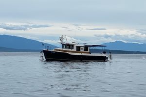 Ranger Tugs R-31S 2015 Ranger Tugs R-31S boat on calm water with mountainous backdrop.