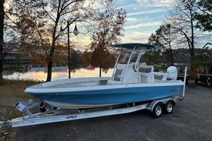 Mako 24 APEX 2025 Mako 24 APEX boat on trailer, parked near a scenic lake at sunset.