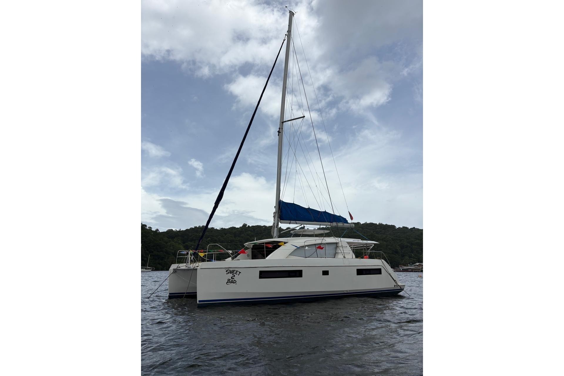Leopard 404 2016 Leopard 404 catamaran with blue sails on a calm water backdrop.