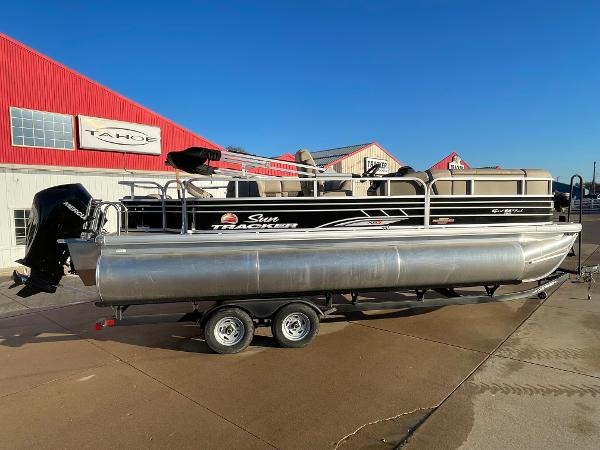 Sun Tracker SportFish 22 XP3 2023 Sun Tracker SportFish 22 XP3 pontoon boat on trailer, parked outside dealership.