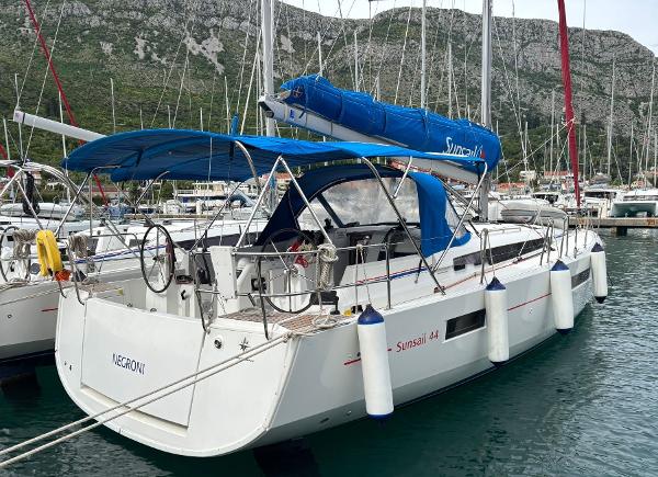 Jeanneau Sun Odyssey 440 2019 Jeanneau Sun Odyssey 440 sailboat docked in a marina, featuring blue canopy and sails.