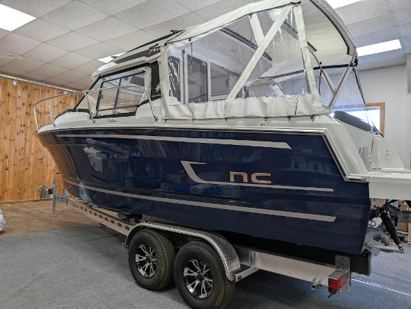 Jeanneau NC795 S2 2024 Jeanneau NC795 S2 boat on trailer in showroom setting.