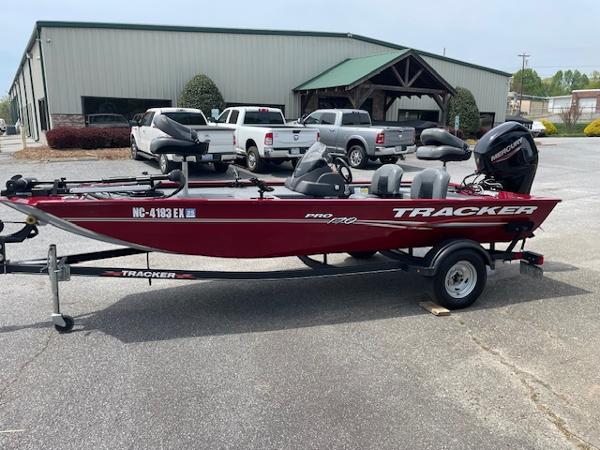 Tracker Pro Team 170 TX 2022 Tracker PRO170 boat on trailer, red color, parked near industrial building.