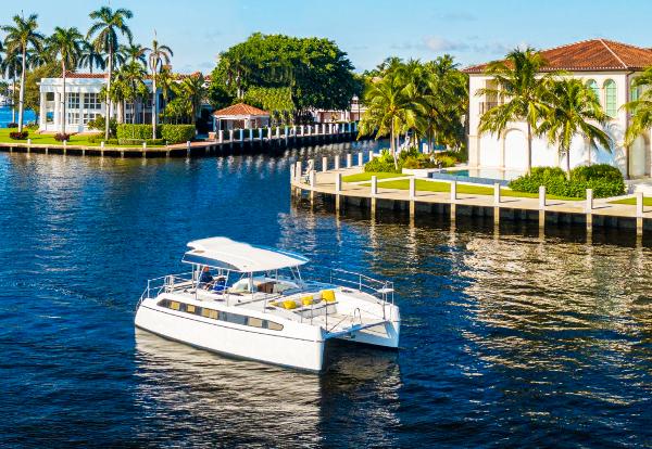 Smart Cat E280 Electric Modern Smart Cat E280 Electric yacht cruising near luxury waterfront homes.