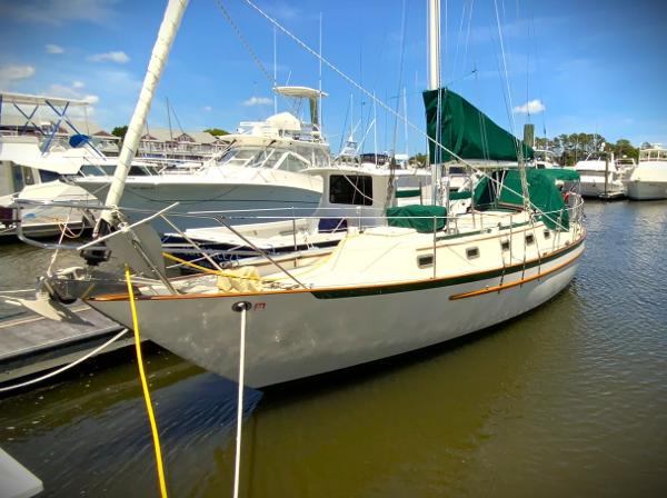 Pacific Seacraft 34 1994 Pacific Seacraft 34 sailboat docked in marina, green sail cover, sunny day.