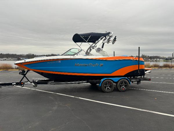 MasterCraft XT22 2020 MasterCraft XT22 boat with blue and orange design on a trailer.