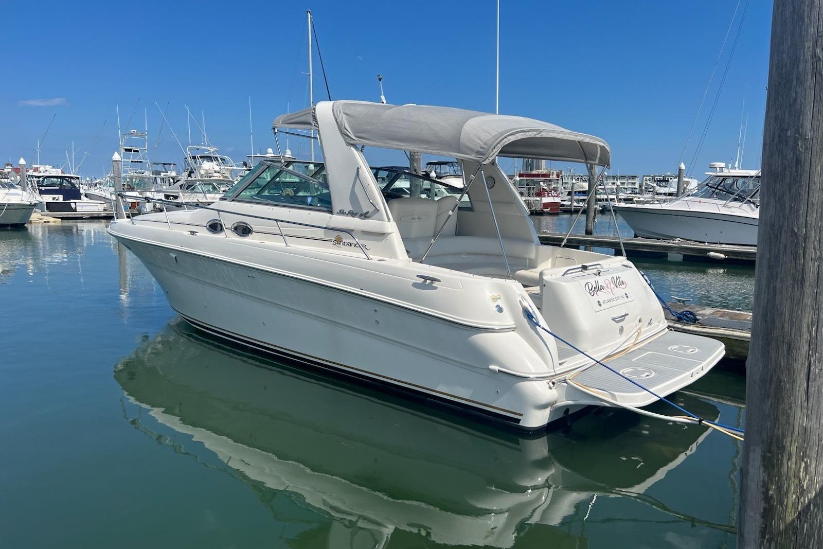 Sea Ray 310 Sundancer 2001 Sea Ray 310 Sundancer boat docked in a marina under clear blue skies.