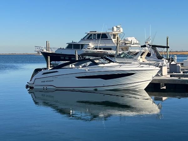 Parker Poland 850 Voyager 2023 Hussar 850 boat docked at marina, reflecting on calm water.