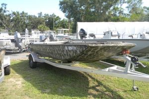 Avid 18 Commander 2025 Avid 18 Commander boat on trailer, camo design, parked outdoors.