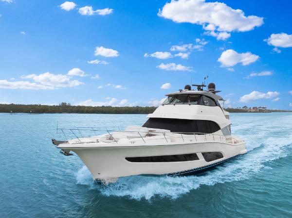 Riviera 64 Sports Motor Yacht 2023 Riviera 64 Sports Motor Yacht cruising on blue water under a clear sky.