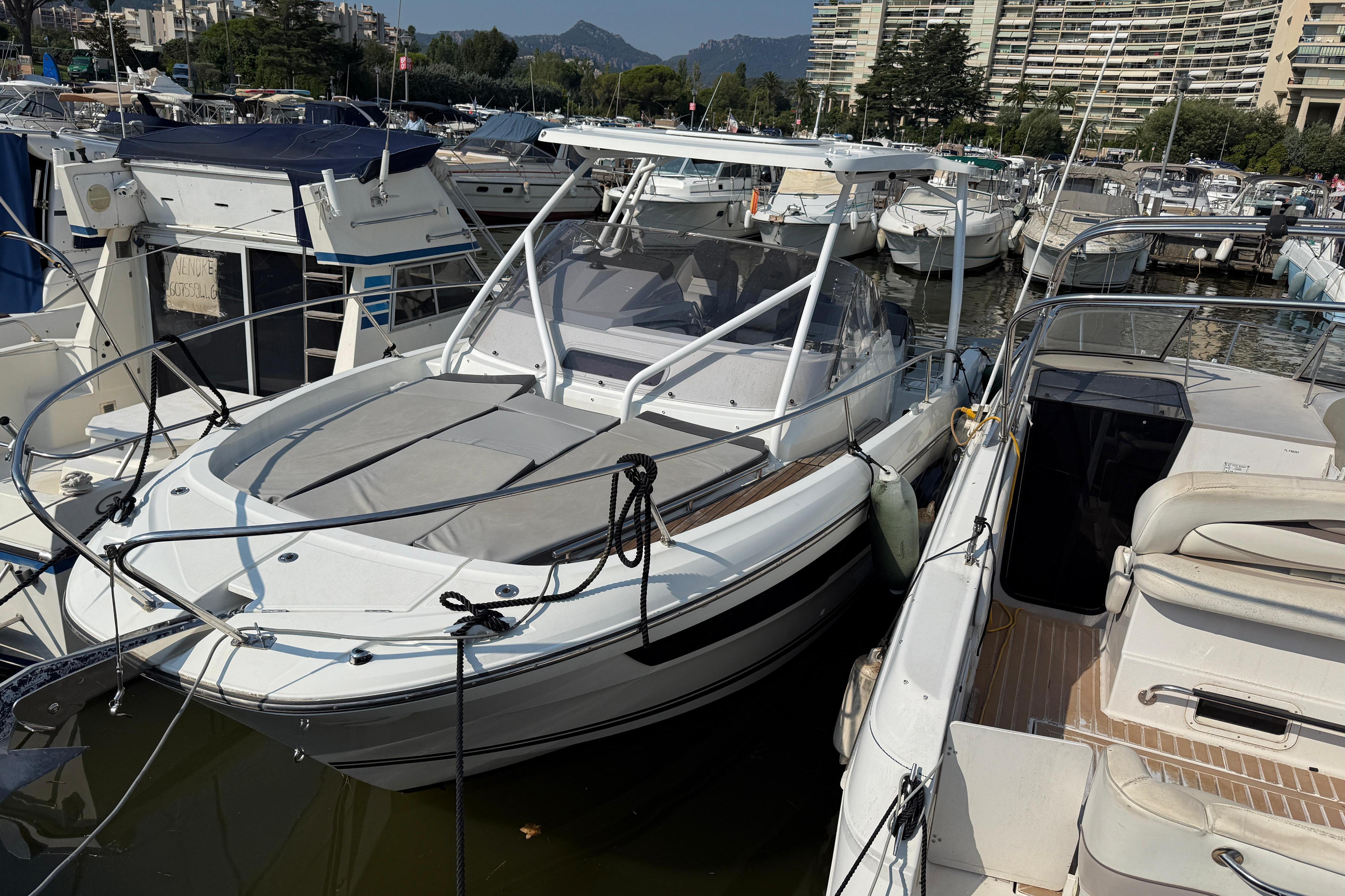 Jeanneau Cap Camarat 9.0 wa 2021 Jeanneau Cap Camarat 9.0 WA boat docked in a marina, surrounded by other vessels.