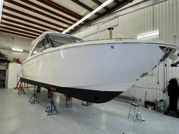 Regal LS36 2023 Regal LS36 boat in a workshop, elevated on stands for maintenance.