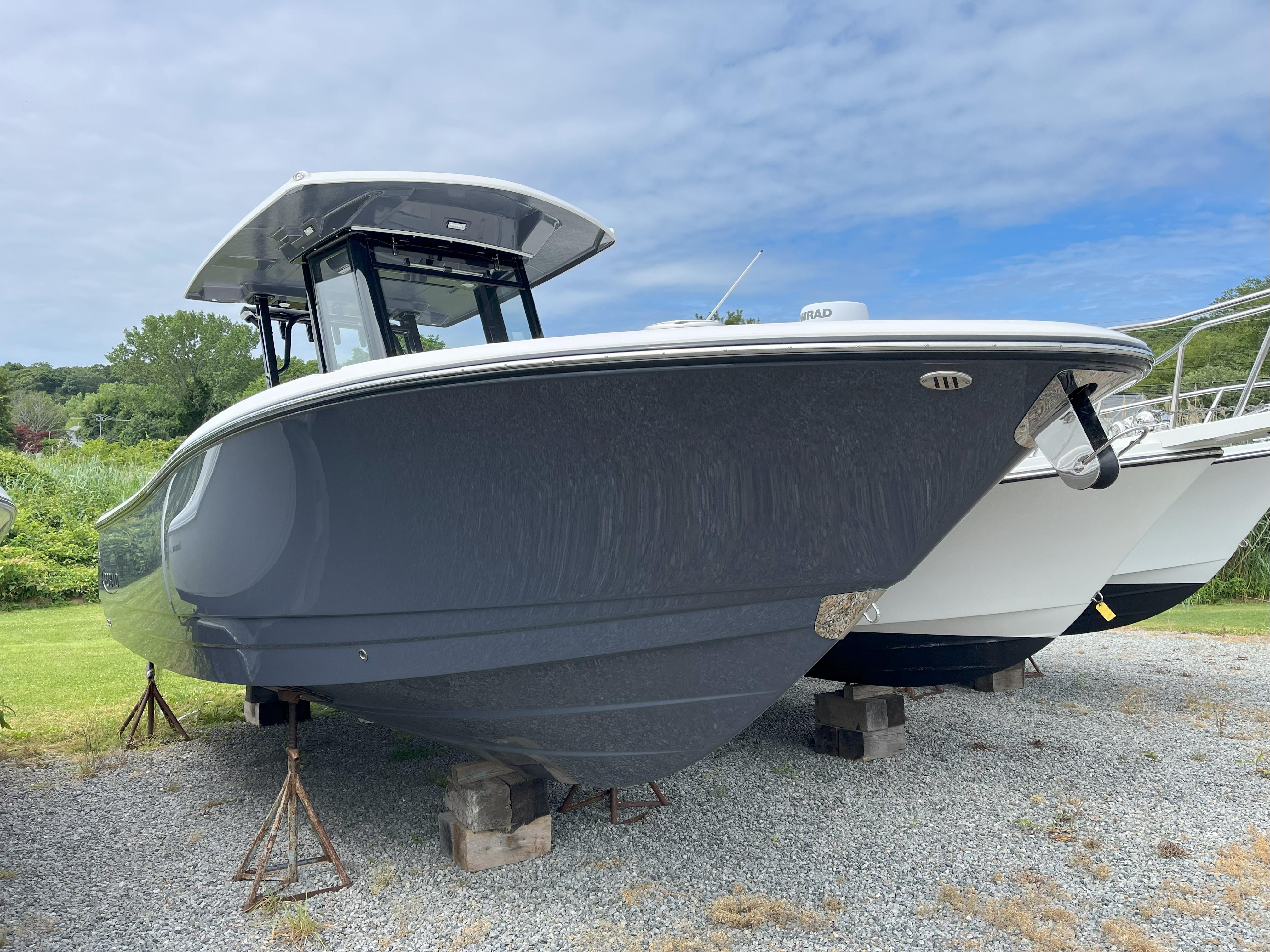 Robalo R270 Center Console 2025 Robalo R270 Center Console boat on stands, outdoors, under a cloudy sky.