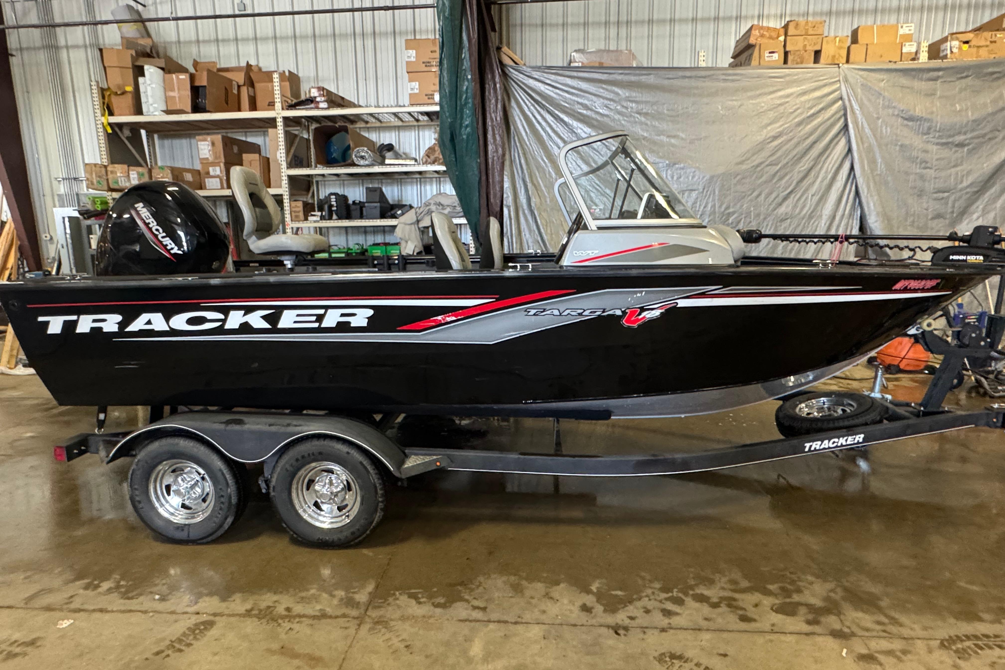Tracker Targa V-18 WT 2019 Tracker Targa V-18 WT boat on trailer in a warehouse setting.