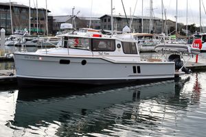 Ranger Tugs R-27 2021 Ranger Tugs R-27 boat docked in marina, surrounded by other vessels.