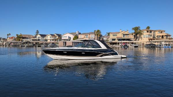 Formula 350 Sun Sport 2015 Formula 350 Sun Sport boat cruising on a calm lake near waterfront homes.