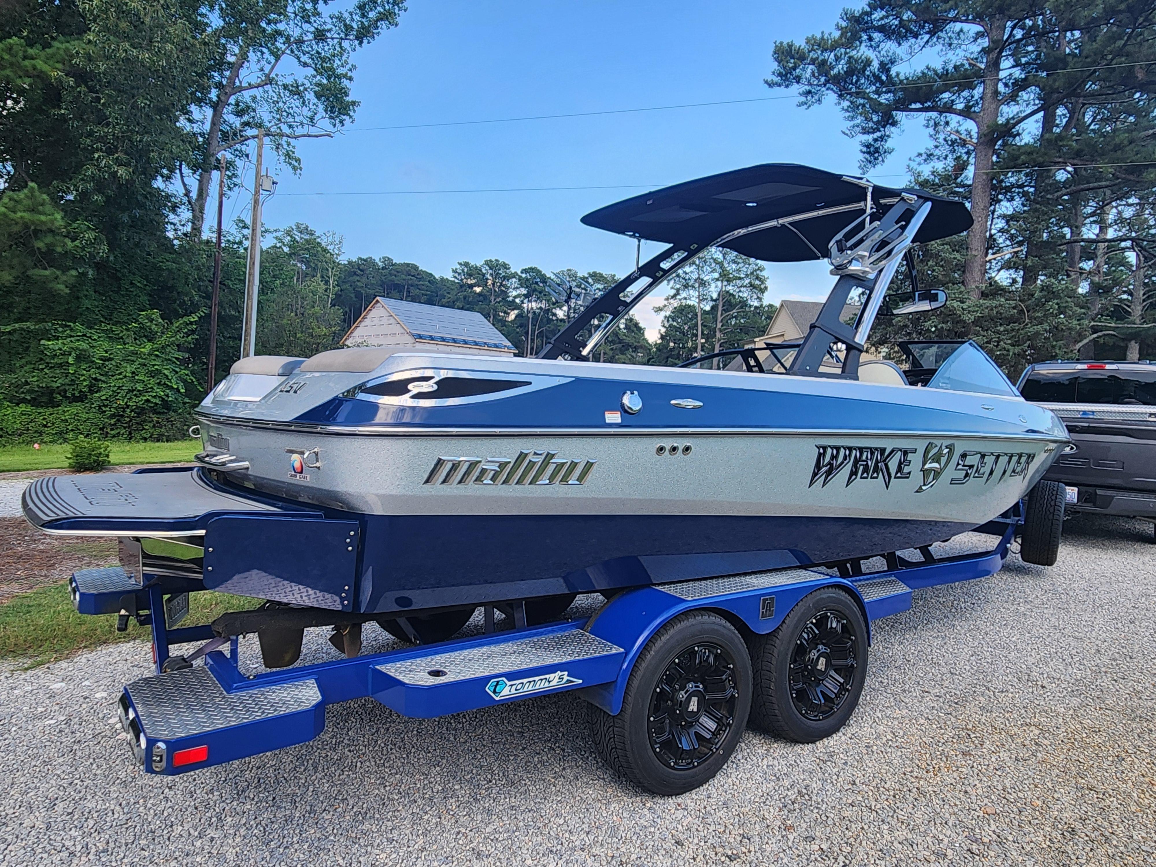 Malibu Wakesetter 23 LSV 2013 Malibu Wakesetter 23 LSV boat on a trailer, parked outdoors.